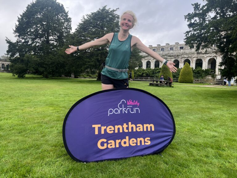 Trentham Gardens parkrun, parkrun, Trentham Gardens, Stoke-on-Trent, parkrun tourism, Female runner with large Trentham Gardens sign