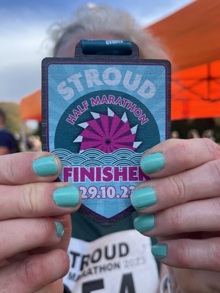 Stroud half marathon, Stroud half marathon medal, Medal, Running, Runner, Close-up of a blue and pink wooden medal which says Stroud half marathon held by a woman with blue nails, Silent Sunday, My Sunday Photo