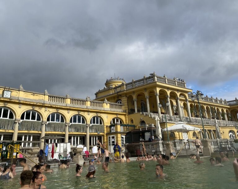 Szechenyi Spa, Spa, Budapest, Hungary, Things to do in Budapest, An intricate yellow building with lots of windows next to a swimming pool