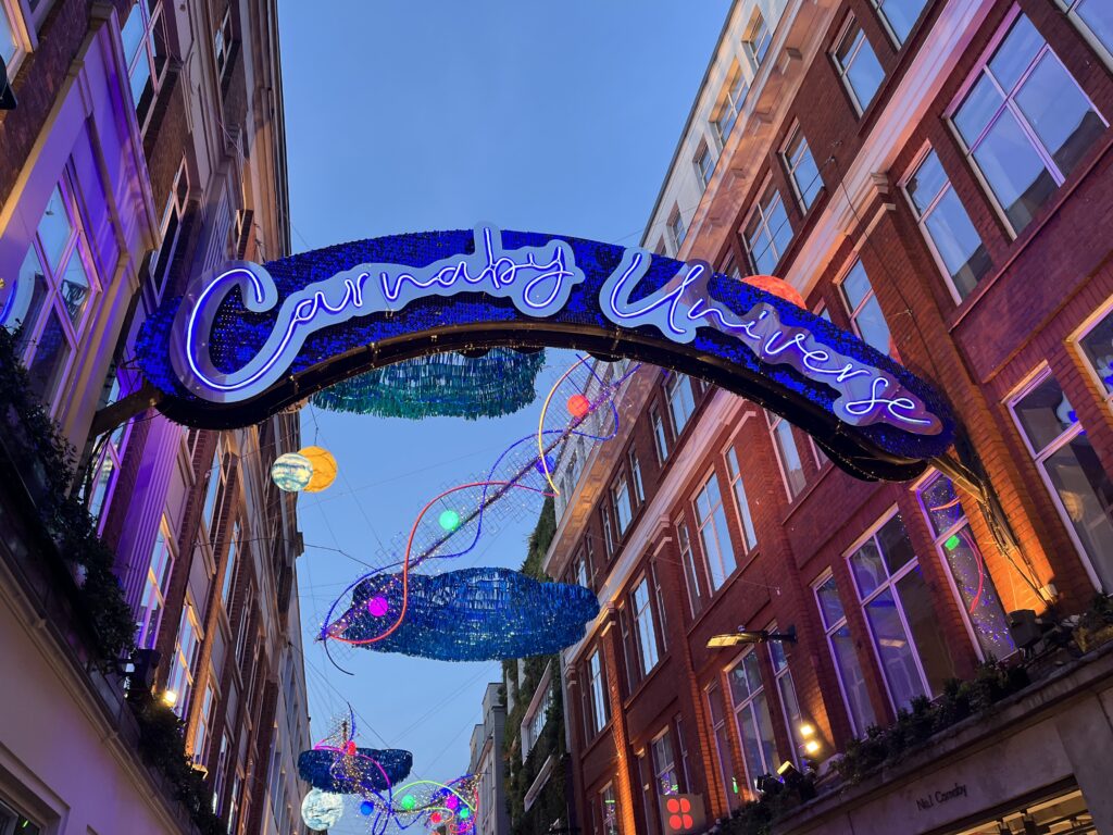 Christmas lights, Carnaby Street, Carnaby Christmas lights, London, The sky is dark blue and there is a lit sign reading Carnaby Universe hung between two tall buildings with other Christmas lights in the background, Silent Sunday, My Sunday Photo