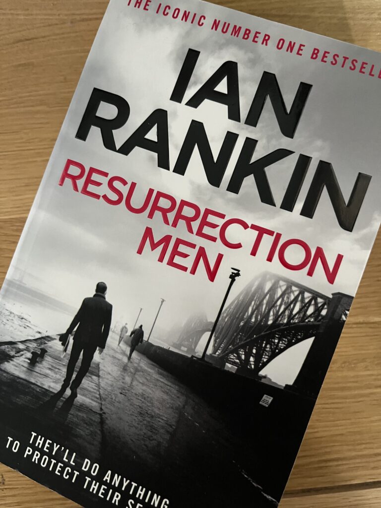 Resurrection Men by Ian Rankin, Resurrection Men, Ian Rankin, Book review, A grey and black book called Resurrection Men by Ian Rankin sits on a wooden surface