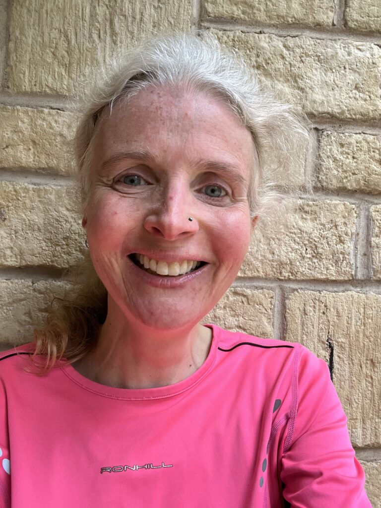 Running selfie, Runner, Marathon training, A smiling woman in a pink top against light coloured bricks