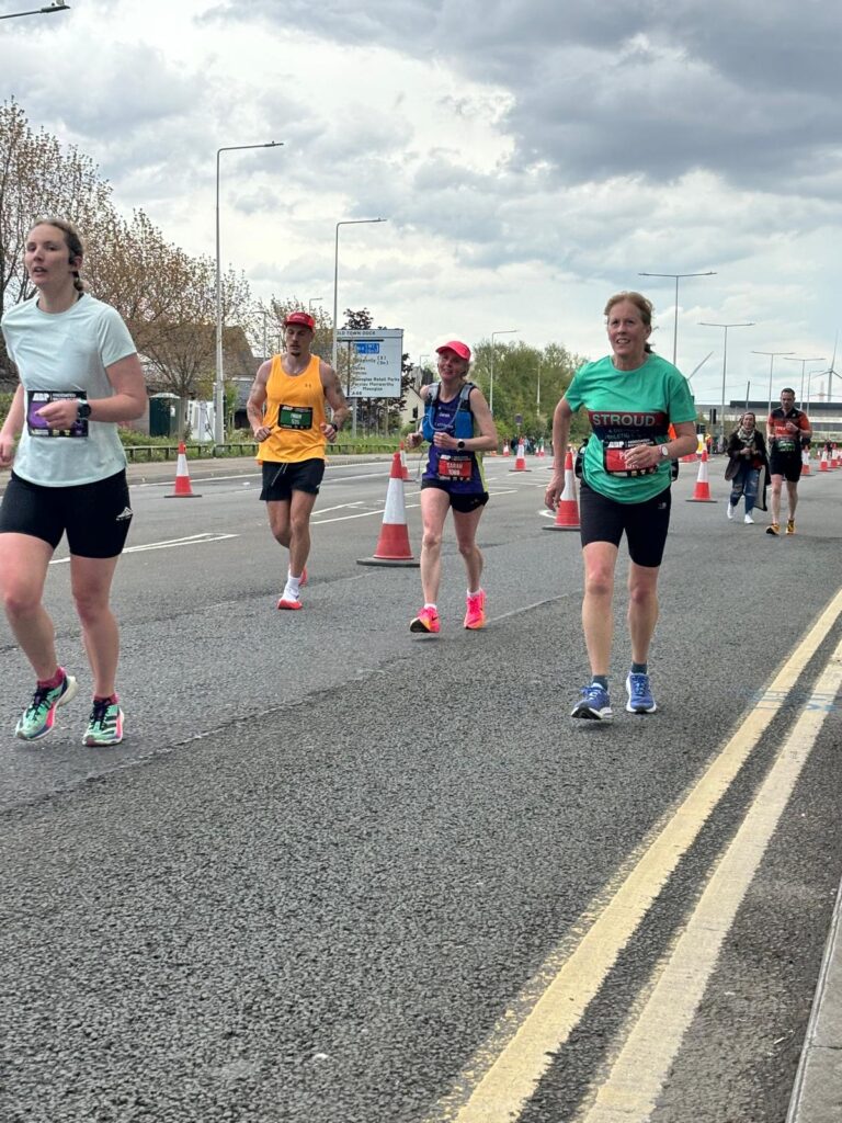 Four runners run along a road with road cones, Running, Runners, Newport marathon
