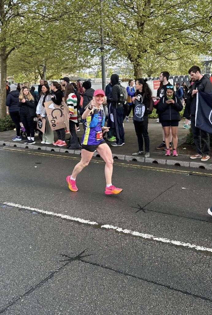 Newport marathon, Running, Runner, A smiling female runner puts her thumb up with crowds in the background