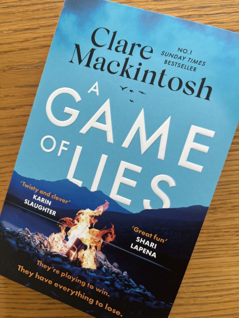 A Game of Lies by Clare Mackintosh, A Game of Lies, Clare Mackintosh, Book review, A blue book called A Game of Lies by Clare Mackintosh sits on a wooden table