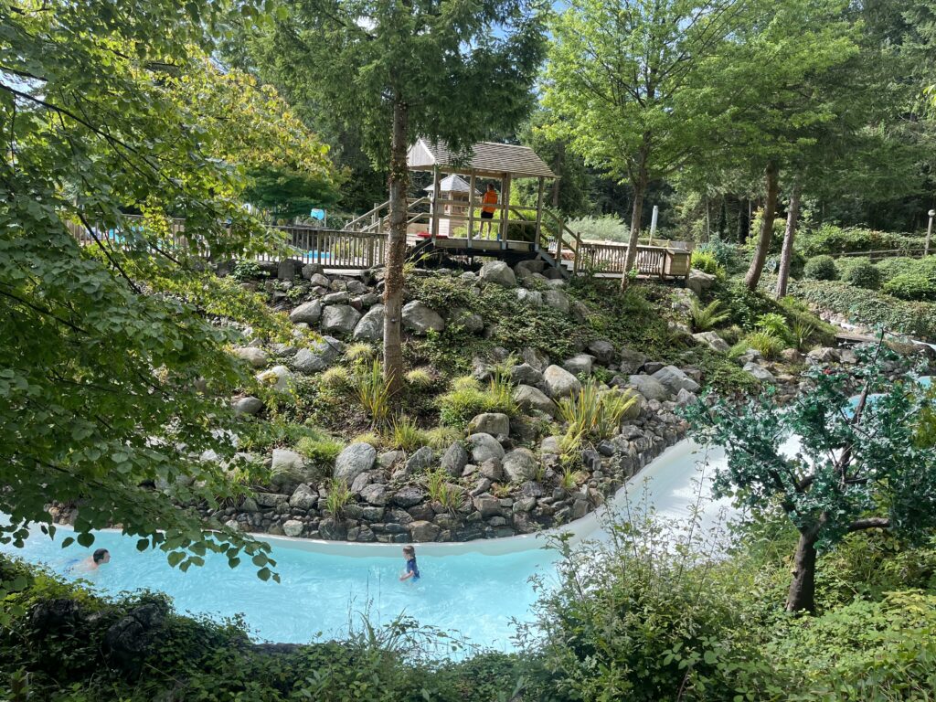 Center Parcs, Center Parcs Longleat, Wild Water Rapids, Silent Sunday, My Sunday Photo, Lots of trees and rocks surround a water slide with a couple of people on it