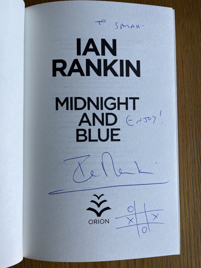Midnight and Blue by Ian Rankin, Midnight and Blue, Ian Rankin, The white title page of a book called Midnight and Blue by Ian Rankin has been signed in blue biro to Sarah and with a noughts and crosses game