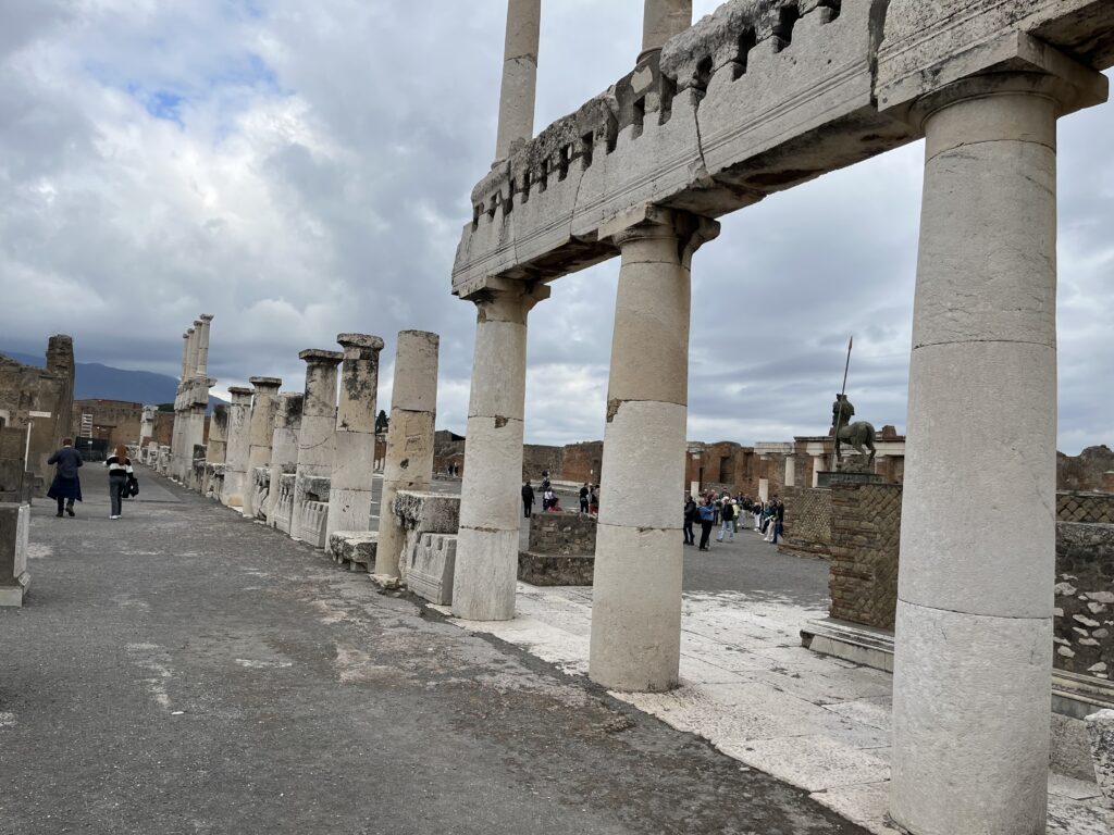 Pompeii, Italy, Tourist attraction, A series of tall whit columns of varying heights with people in the background