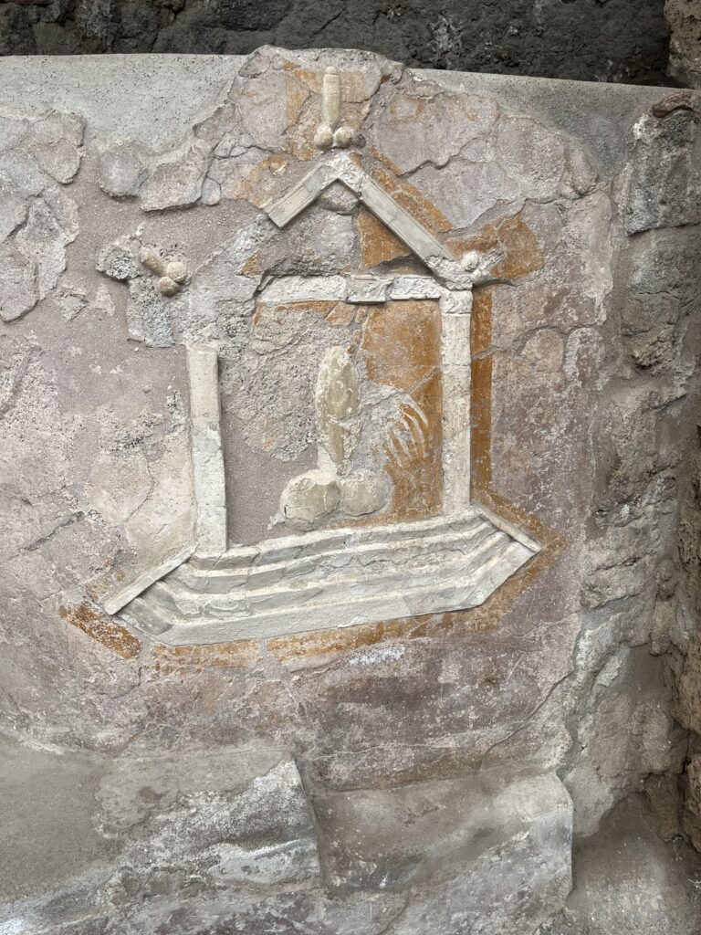 Pompeii, Roman ruins, Italy, Sorrento, Tourist attraction, A crumbling stone panel has a large image of a penis on the front with smaller penises around the edge