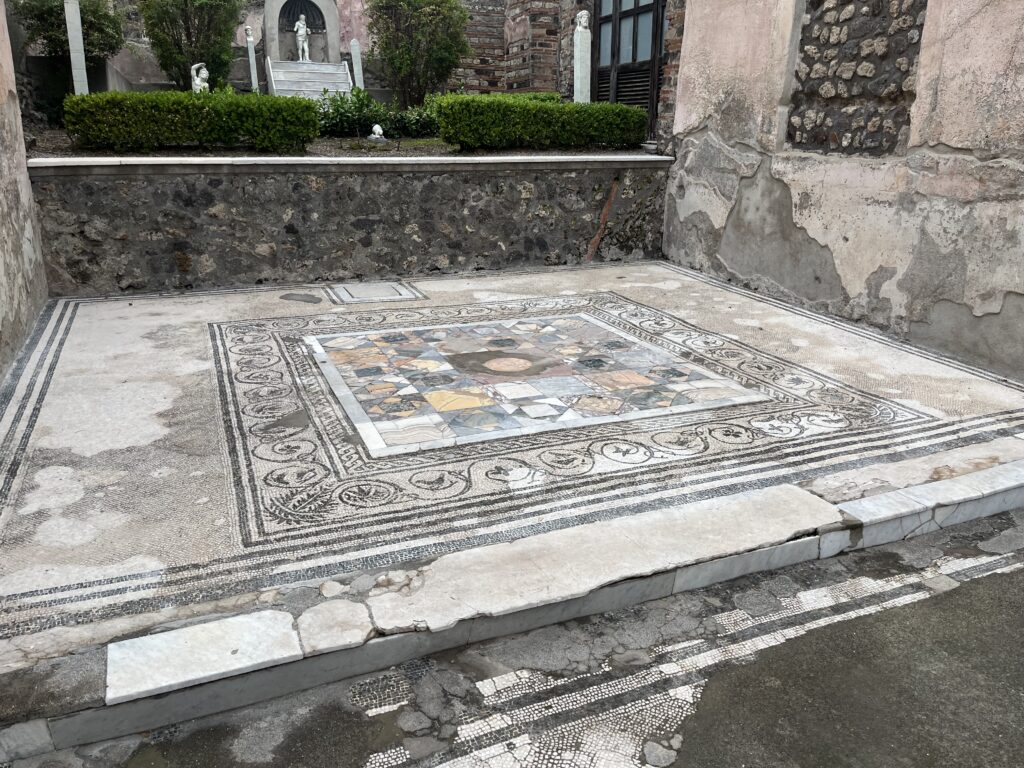 Pompeii, Italy, Tourist attraction, Mosaic, A mainly white mosaic floor with intricate patterns surrounded by ruined walls