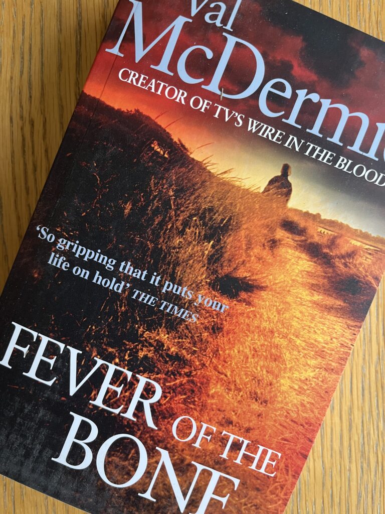 Fever of the Bone by Val McDermid, Fever of the Bone, Val McDermid, Book review, A book with a dramatic orange cover called Fever of the Bone by Val McDermid sits on a wooden table