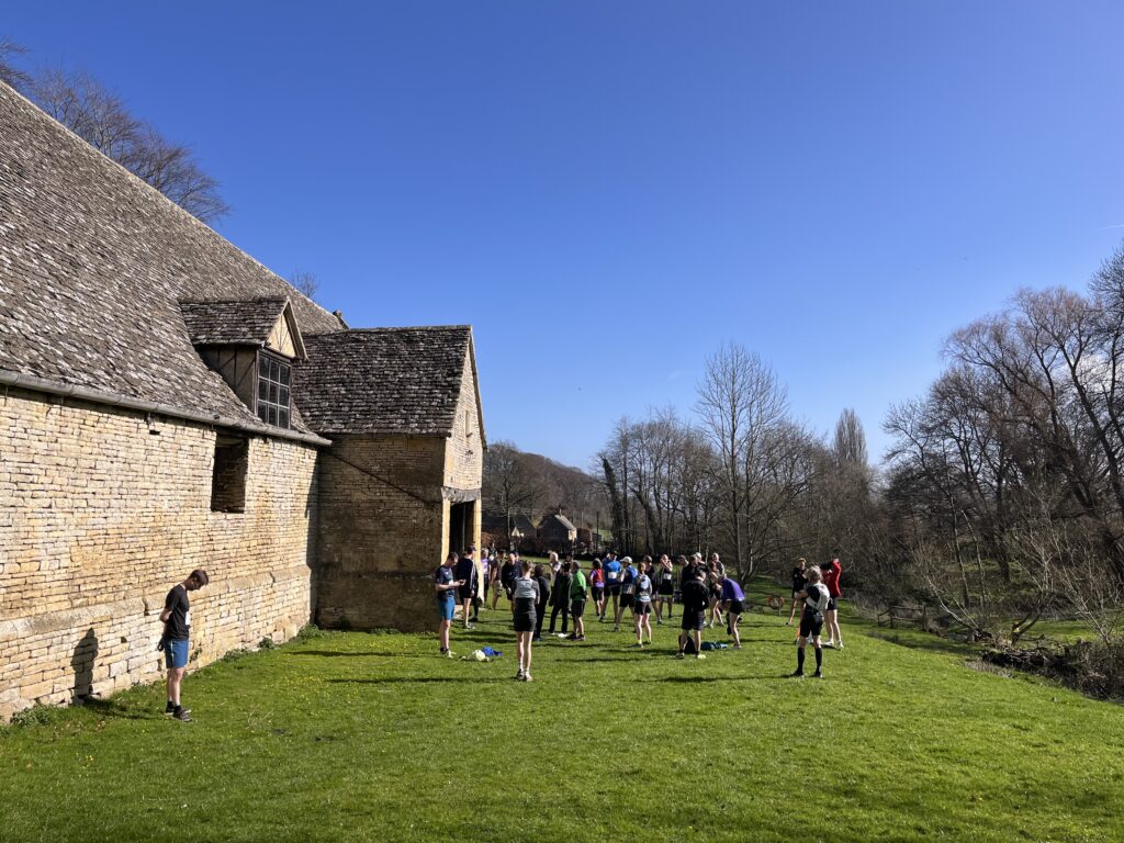 Cleevewold, Runners, Running, A group of runners stand on the grass outside a light coloured building against a blue sky