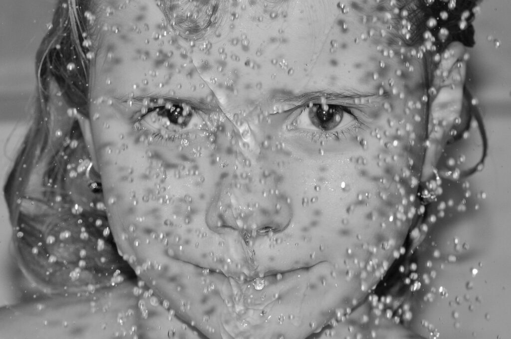 Child in the shower, Shower cabin, Black and white portrait of a child's face with water drops on the lens and on their face