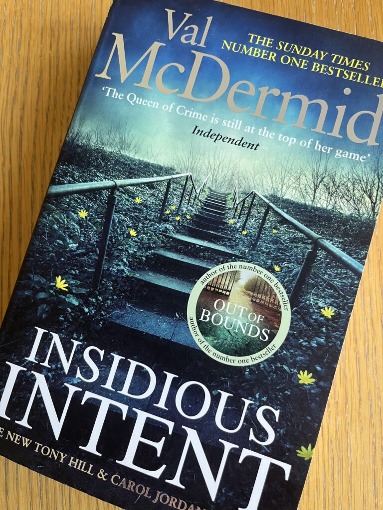 Insidious Intent by Val McDermid, Insidious Intent, Val McDermid, Book review, A blue book called Insidious Intent by Val McDermid showing a flight of outdoor stairs going up sits on a wooden table
