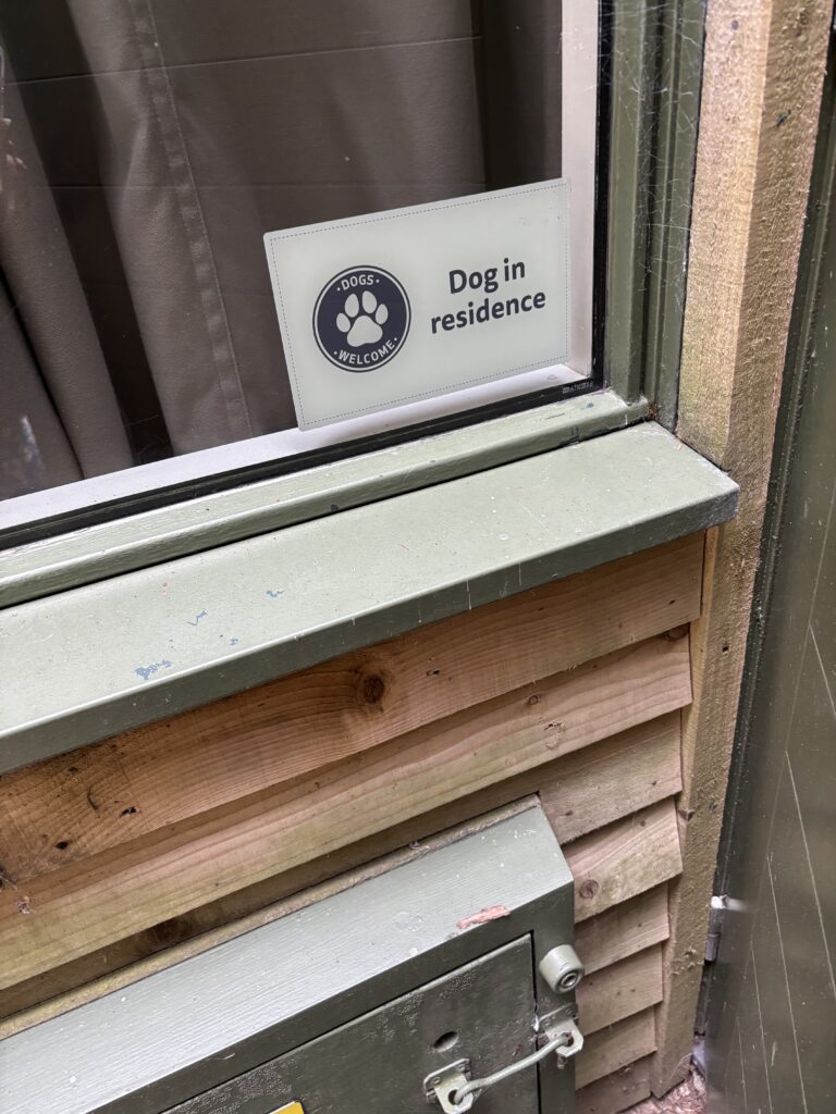 Center Parcs, Dog friendly lodge, Close-up of a window on a wooden building with a Dog in residence sticker in the window