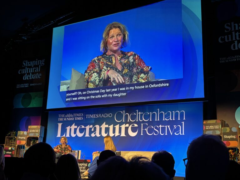 Joanna Page, Gavin and Stacey, Cheltenham Literature Festival, Silent Sunday, My Sunday Photo, A large blue screen shows the actress Joanna Page speaking above a sign which says Cheltenham Literature Festival in a dark room in front of an audience with Joanna just visible on a chair on a stage below the screen