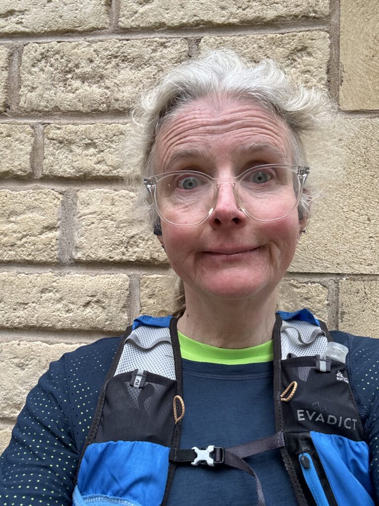 Marathon training, Running, Runner, A female runner in glasses looks unhappy standing aganst a pale brick wall