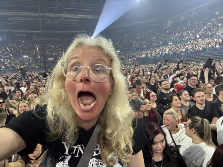 Yungblud, Yungblud live, Idols World Tour, Birmingham Utilita Arena, Birmingham, A woman with long fair hair and glasses looking excited and scared above a large crowd of people in an arean