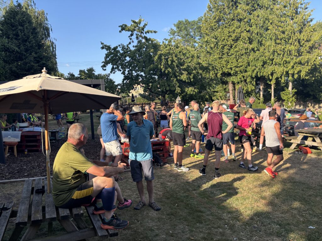 Dave Lucas Memorial 10k, Runners, Running, A crowd of runners stand in a pub garden on a sunny day against blue sky and green trees